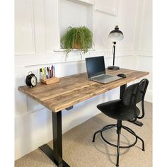 a laptop computer sitting on top of a wooden desk next to a lamp and chair