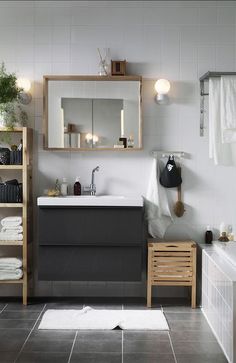 a bathroom with a sink, mirror and shelving unit