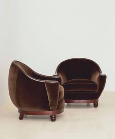 two chairs sitting next to each other on top of a table in front of a white wall