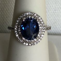 a ring with a blue stone surrounded by white diamonds