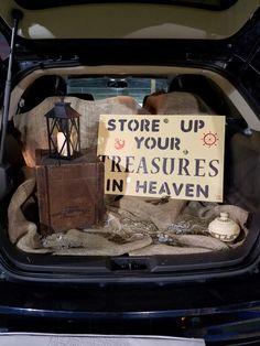 the trunk of a car is filled with items that include candles, books and bags