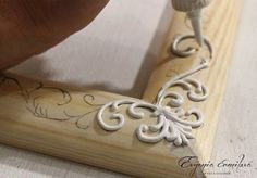 someone is using a carving tool to cut out decorative designs on a piece of wood