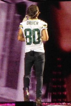 a football player standing on top of a stage with his hands in his pockets,