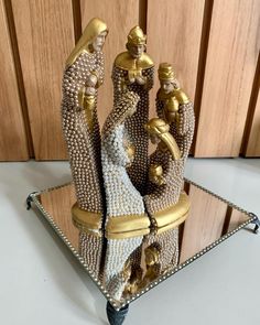 a glass tray with some gold and silver items on it