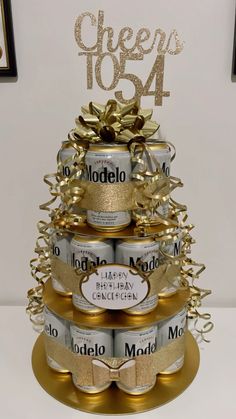 a three tiered cake made out of cans with gold ribbon and bow on top