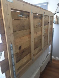 a bed frame made out of pallet wood with metal brackets on the bottom and sides