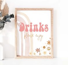 a wooden frame with the words drinks please enjoy on it next to a vase and flowers