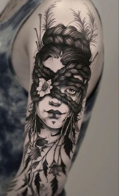 a woman's face with feathers on her head and behind her is a black and white tattoo