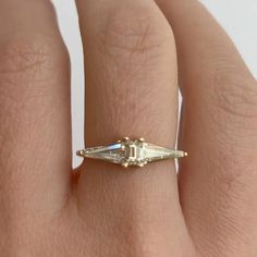 a woman's hand with a diamond ring on it