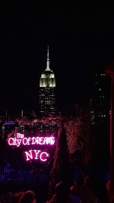 the city of dreams sign is lit up at night