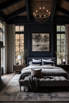 a large bed sitting under a chandelier in a bedroom next to two windows