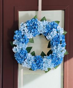 a blue wreath is hanging on the front door