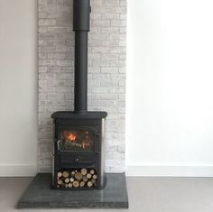 a fire place in the corner of a room with white brick walls and flooring