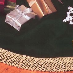 two wrapped presents are sitting on a lace doily with snowflakes in the background