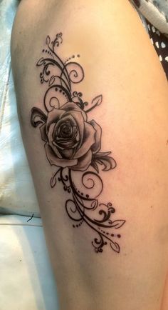 a woman's thigh with a rose tattoo on it