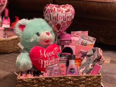 a blue teddy bear sitting in a basket filled with valentine's day items