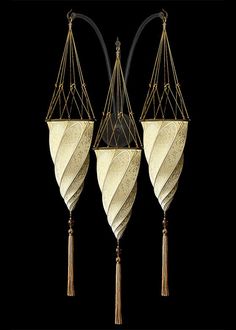 three decorative hanging lamps with tassels on each side, one in gold and the other in black