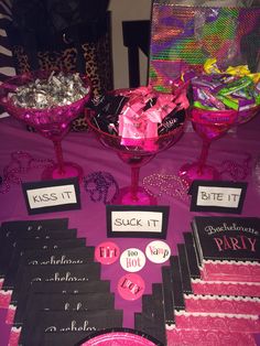 a table topped with lots of pink and black items on top of a purple table cloth