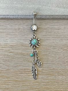 Elevate your boho-chic style with this mesmerizing belly button ring, showcasing a radiant faux turquoise sun design paired with elegant, dangling feather charms. Crafted from high-quality 316L surgical steel, this belly button piercing offers stunning beauty and quality. The vibrant faux turquoise stone, set against the backdrop of the sun design, adds a pop of color and a sense of natural energy to your look. The dainty feathers sway gracefully with each step, creating an eye-catching movement Button Piercing, Belly Button Jewelry, Daith Earrings, Sun Design, Reversible Top, Industrial Piercing, Eyebrow Piercing, Sun Designs, Belly Button Ring