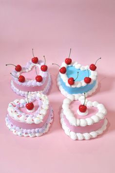 three cakes with cherries on top and one is made out of cake icing