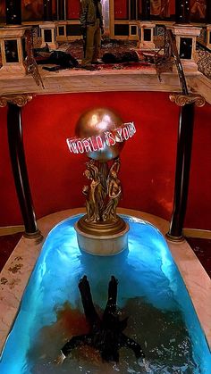 a man standing in front of a trophy on top of a blue pool with water