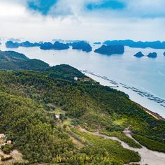 an aerial view of the ocean and land with mountains in the background