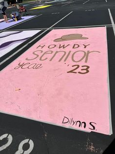 people are walking on the sidewalk painted with pink and purple colors, along with an arrow