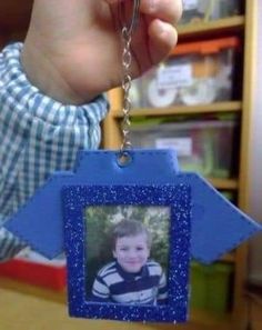 a hand holding a keychain with a photo on it in the shape of an arrow