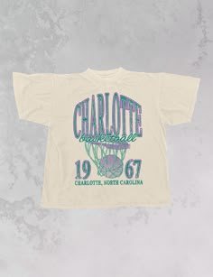 Show the love for your favorite team in this Charlotte, NC Basketball oversized tshirt that is inspired by vintage 90s N B A tshirts! - Features Charlotte Basketball across the top with a basketball hoop and 1967 with Charlotte, North Carolina underneath all in a purple and teal ink - Screen print transfer that is heat pressed onto each tshirt- Tshirt is a super soft vintage wash that gets softer after each wash- Oversized fit- Sizing translation: XS/S - L , S/M - XL , L/XL - 2XL , 2XL/3XL - 3XL * colors may vary slightly due to screens and filters * Vintage Sports Shirt, Basketball Apparel, Charlotte Basketball, Basketball Logo, 90s Sports, Screen Print Transfer, Merch Design, Purple And Teal, Print Transfer