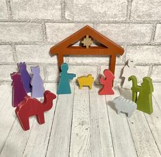 a wooden nativity scene with figurines in the shape of people and a manger