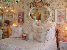 a bed with pink flowers on it and chandelier hanging from the ceiling above