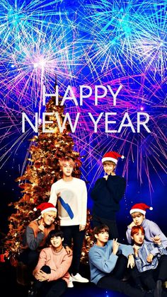 the group is posing for a photo in front of fireworks and a christmas tree that says happy new year