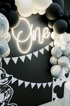 a black and white party with balloons, streamers and one sign on the wall