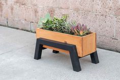 a small wooden planter with succulents in it