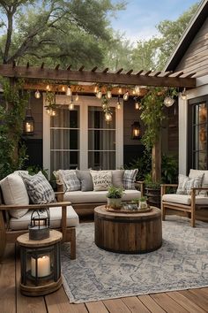 an outdoor living area with couches, tables and lights hanging from the pergolated roof