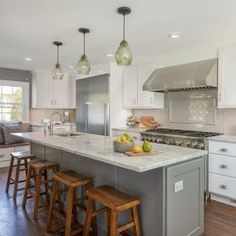 a kitchen with an island and stools in it