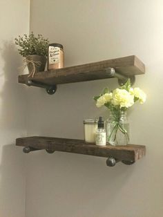 two wooden shelves with flowers and candles on them