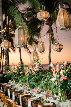 an outdoor dining area with tables and chairs set up for a dinner under palm trees