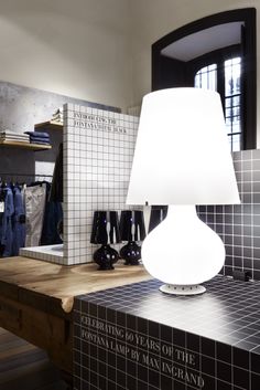 a lamp is sitting on top of a counter in a room with tiled walls and flooring