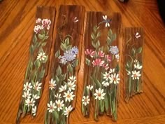 three pieces of wood with flowers painted on them