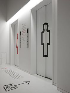 an empty room with white walls and black artwork on the floor next to two doors