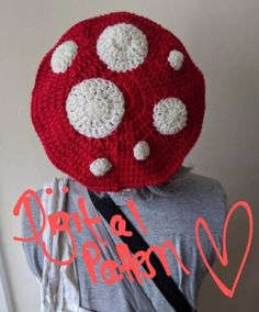 a woman wearing a crocheted red and white hat with polka dots on it