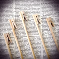 four wooden clothes pins on top of an old book