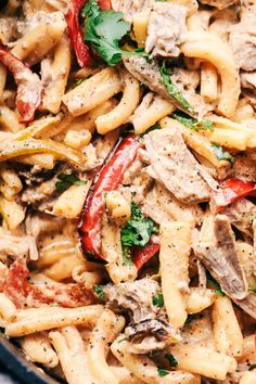 pasta with chicken, peppers and parsley in a skillet