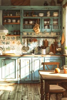 an old fashioned kitchen with blue cabinets and wooden floors, including a table in the center