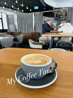 a cup of coffee sitting on top of a saucer next to a wooden table