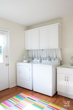 a white washer and dryer sitting next to each other on top of a wooden floor