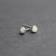 These tiny opal stud earrings are so dainty and beautiful.  They feature a single 3mm simulated opal cabochon.  Completely handmade in my studio using solid 925 sterling silver or gold fill.  I have hand soldered the bezels to the studs and mounted the stones within them.  The simulated opal cabochons are 3mm in diameter.  These are perfect for second piercings! They will arrive carefully packaged in a small signature jewelry box.  I also have these in larger sizes:4mm:  https://www.etsy.com/lis Dainty Hypoallergenic Opal Earrings, Minimalist Hypoallergenic Opal Earrings, Minimalist Opal Earrings, Dainty White Opal Earrings, Minimalist White Opal Earrings, White Dainty Nickel-free Cartilage Earrings, Dainty White Nickel-free Cartilage Earrings, Dainty Tiny White Cartilage Earrings, Second Piercings