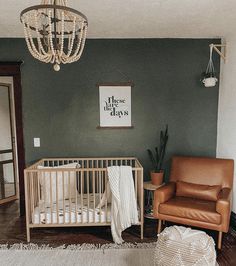 a baby's room with a crib, chair and chandelier hanging from the ceiling