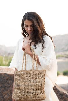 This hand-woven banana fiber handbag is a perfect blend of natural elegance and durability. Crafted by skilled artisans, each bag showcases intricate weaving patterns that highlight the unique texture of banana fibers. Lightweight yet sturdy, it's ideal for both casual outings and special occasions. The eco-friendly material ensures sustainability, making it a conscious choice for the environmentally aware. With its earthy tones and organic feel, this handbag complements any outfit effortlessly. Spacious enough to hold all your essentials, it combines functionality with style. Carry a piece of nature with you wherever you go. Eco-friendly Beach Bag With Open Weave, Woven Jute Shoulder Bag, Woven Bags Made Of Natural Fiber In Natural Color, Fair Trade Jute Straw Bag For Beach, Natural Woven Bags Made Of Natural Fiber, Eco-friendly Palm Leaf Bag With Open Weave, Fair Trade Straw Bag For Beach, Natural Straw Bag Fair Trade, Fair Trade Straw Beach Bag